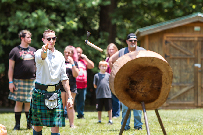 Blairsville, GA / USA - June 9 2018: A man throws a hatchet at wood target in an axe throwing exhibition at the Blairsville Scottish Highland Games at Meeks Park on June 9, 2018 in Blairsville, GA.