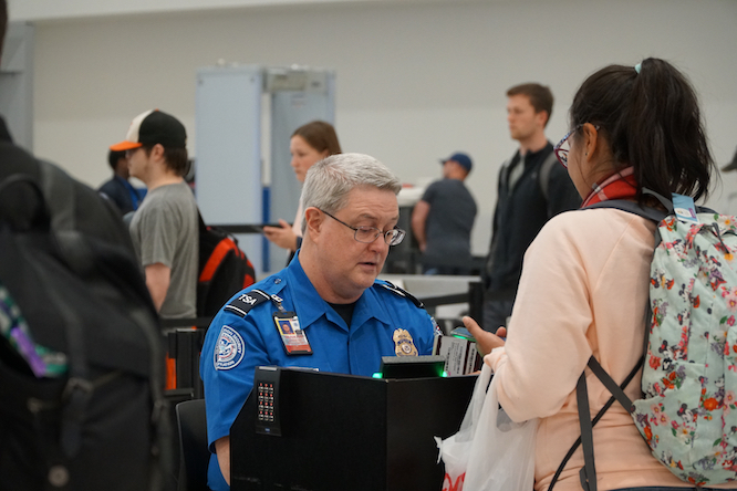 Baltimore, MD, USA - April 8 2019: TSA (Transportation Security Administration) worker checks out passport at the BWI airport.