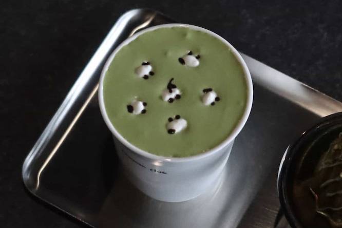a green matcha latte with little sheep drawn in