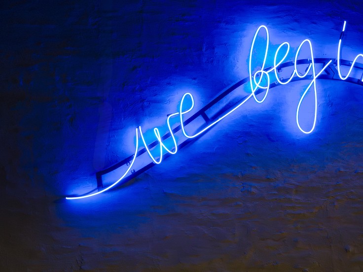 huge blue glowing line of poetry on a building