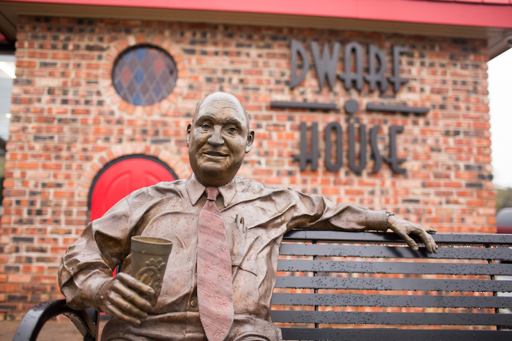 bronze statue of a man sitting on a bench