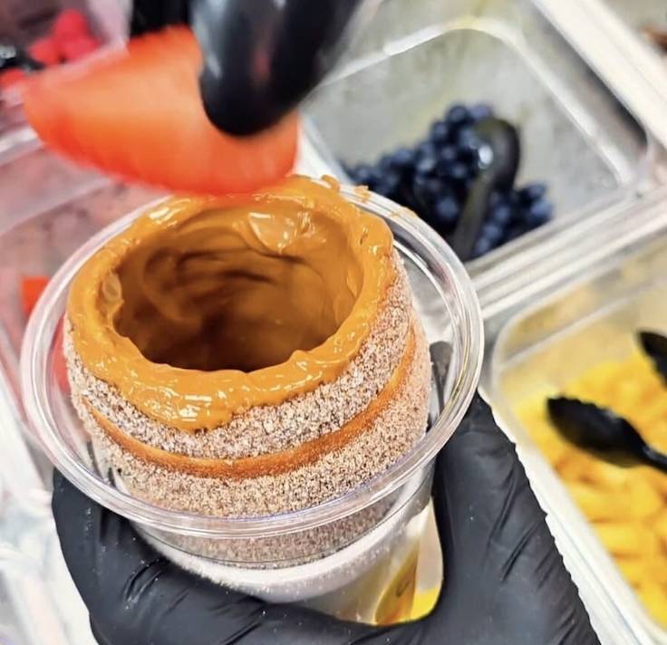 a chimney cake in a cup with strawberries