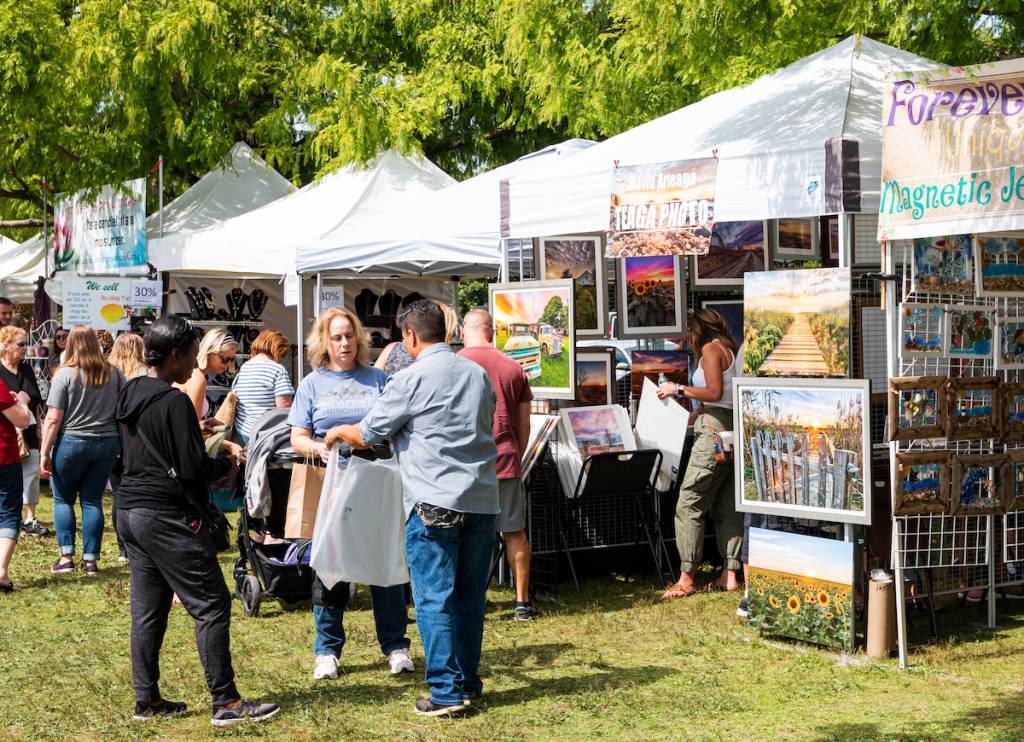 Babylon, New York, USA - 8 September 2019: People enjoying a sunny day walking around Argyle Lake and purchasing goods from vendors during the annual Babylon Beautification Society Fair.