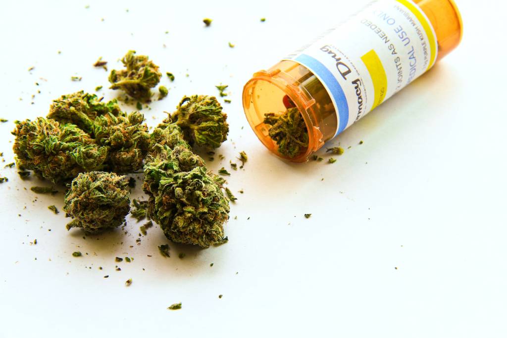 Marihuana medicinal A. Marihuana medicinal saliendo de un frasco de receta sobre fondo blanco. (La etiqueta del frasco es original, así que no hay problemas de marcas registradas ni derechos de autor)