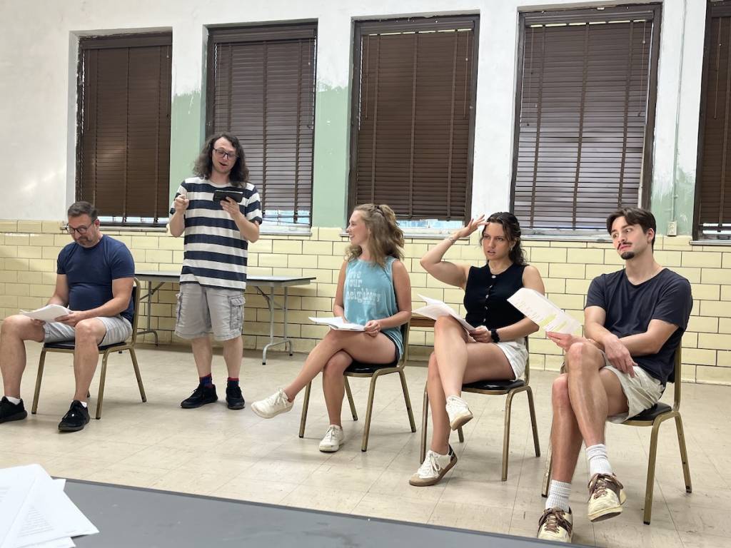 a cast of actors reading scripts