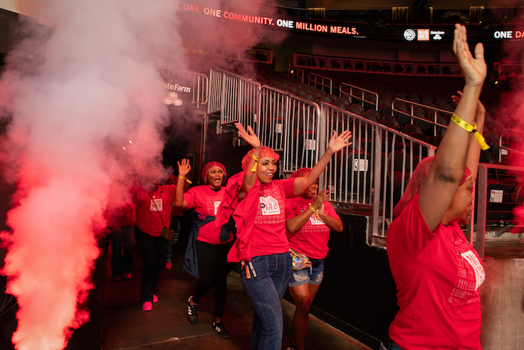 un evento a gran escala de empaquetado de comida en Atlanta, en el State Farm Arena, con los ATL Hawks