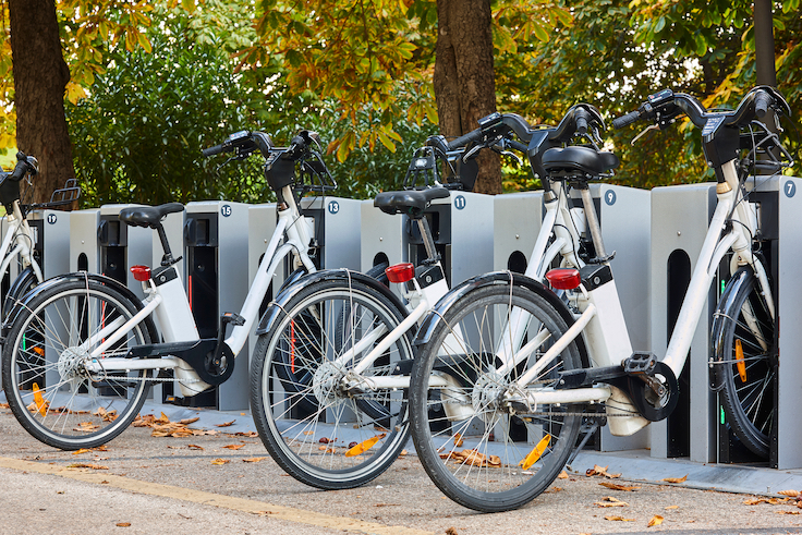 Urban electric bikes charging batteries in the city. For rent