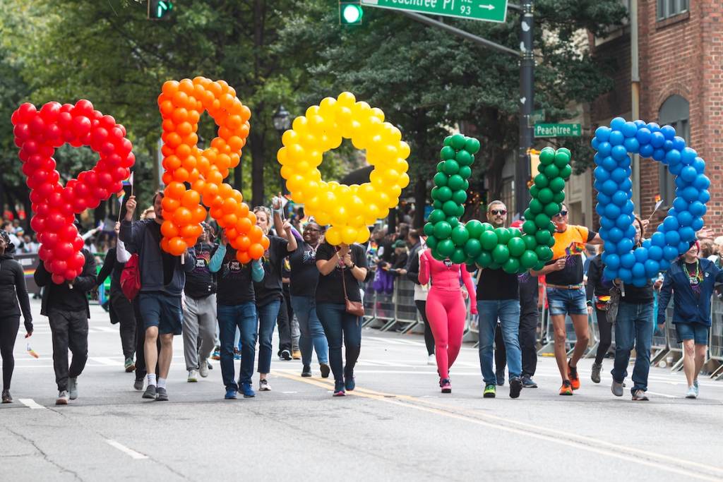 Atlanta, Georgia, EE. UU. - 15 de octubre de 2023: La gente lleva grandes globos con letras que forman la palabra «Proud» mientras desfilan en el desfile anual del Orgullo el 15 de octubre de 2023 en Atlanta, Georgia.