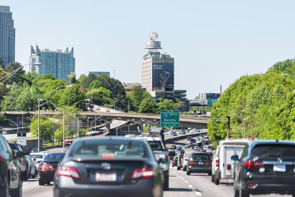 Atlanta, EE. UU. - 20 de abril de 2018: la autopista I-85 (Interstate 85) durante el día en la capital de Georgia, coches en el tráfico, señal de salida hacia Marietta y Chattanooga, y puentes elevados.