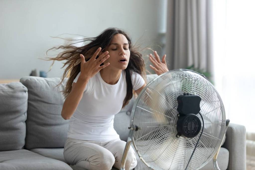 mujer sudando delante de un ventilador
