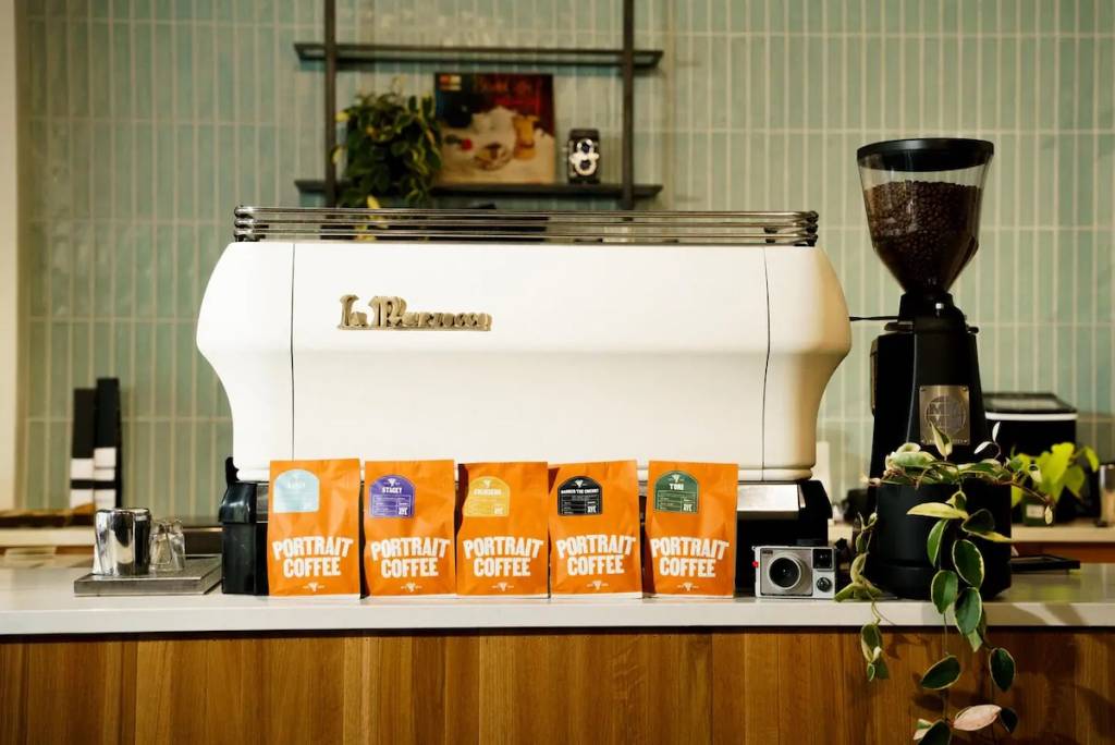 la parte trasera de una máquina de café espresso con sacos de café delante