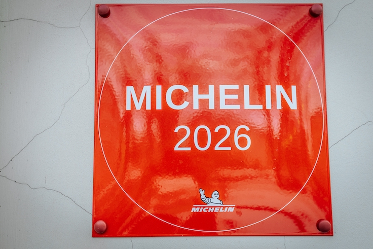Valmiera, Latvia - February 04, 2026. Red Michelin 2026 plaque displayed on a white wall, showcasing a glossy surface with clear text and logo design elements