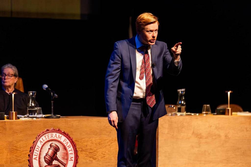 A defense lawyer pointing at the audience during his speech at The Jury Experience