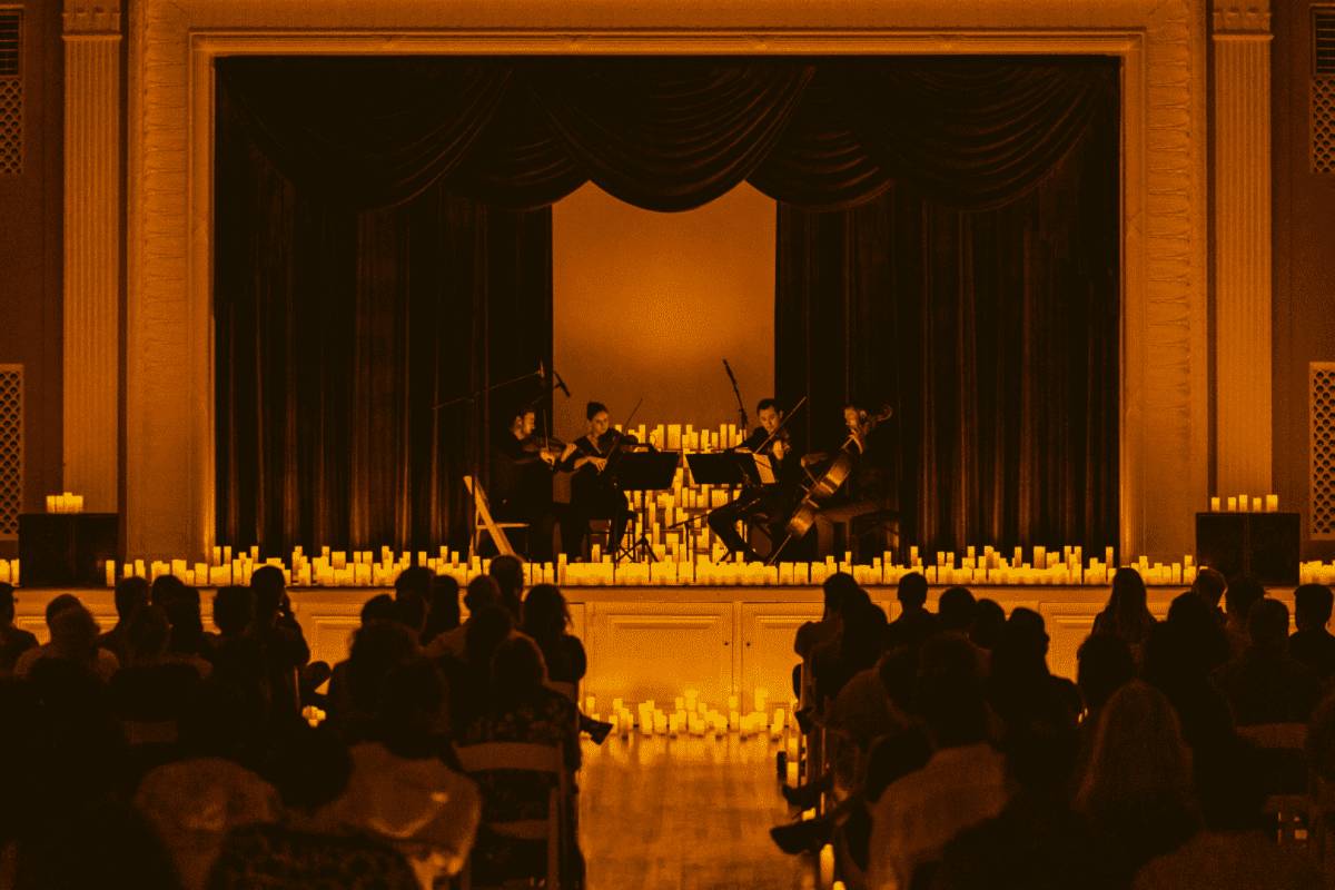 A string quartet performing on stage at a Candlelight concert in Austin's The Mansion