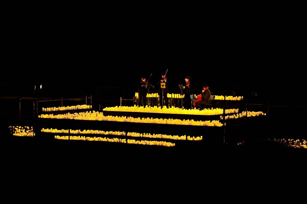 A string quartet is illuminated by candlelight