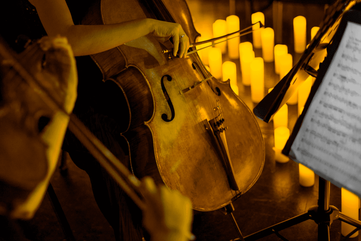 A cello player illuminated by candlelight