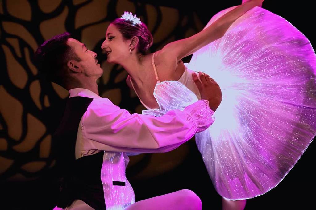 Two ballet dancers in glow-in-the-dark costumes performing at Ballet of Lights
