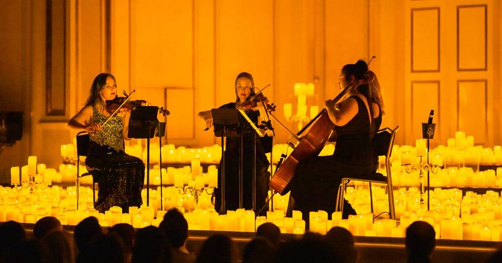 A string quartet performing amid a sea of candles