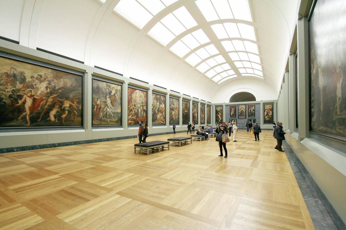heller Museumssaal mit Gemälden an der Wand und gewölbter Decke