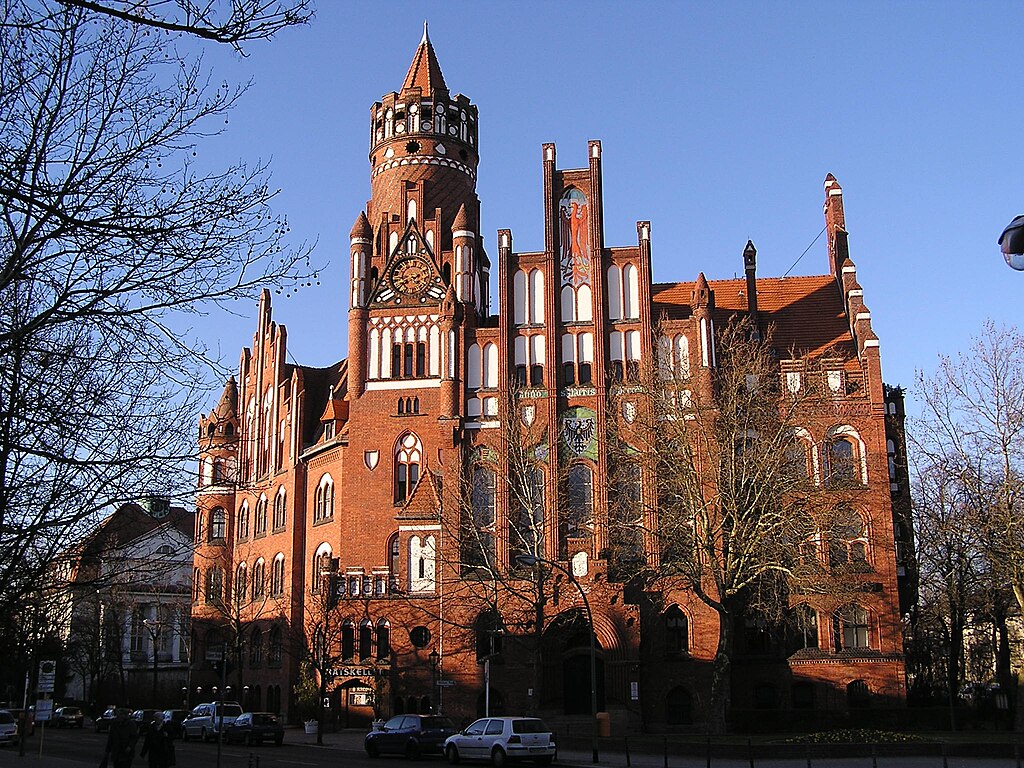Fassade des Rathaus Schmargendorf in Berlin bei Tag, Bäume im Vordergrund