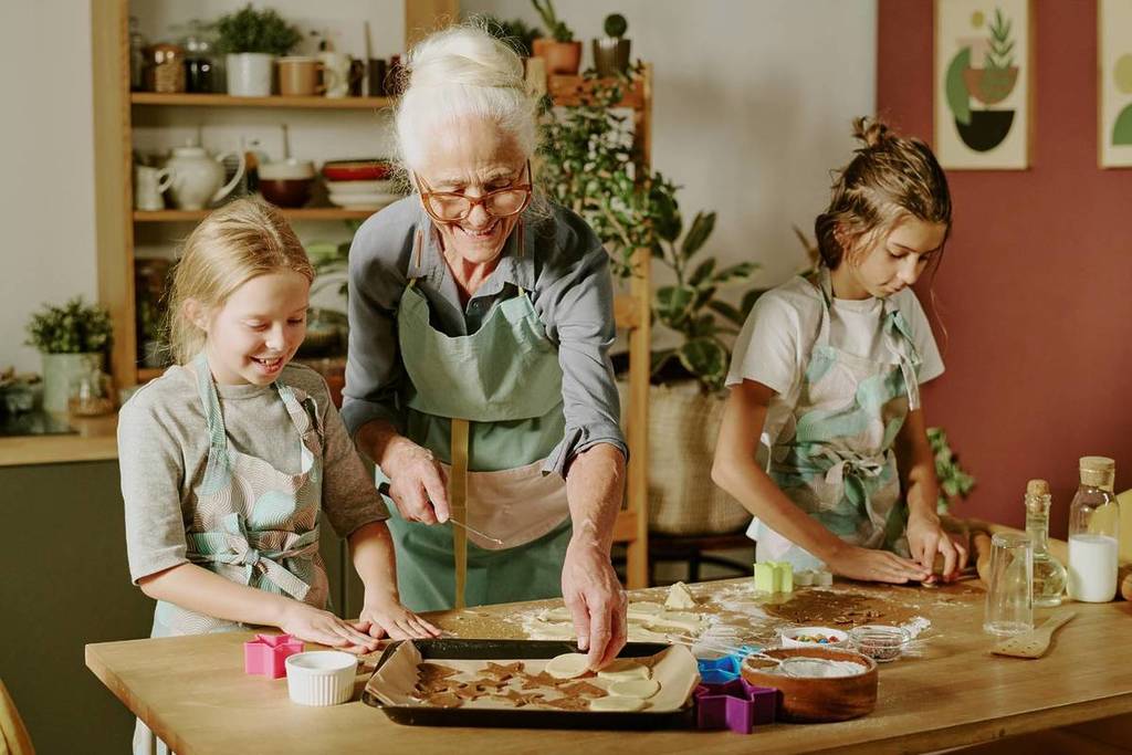 An elderly Berlin woman bakes with her grandchildren.