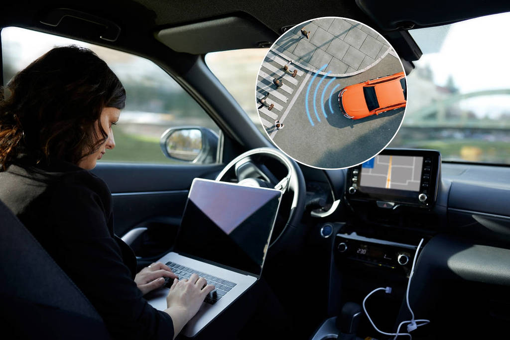 A woman sits in the driver’s seat of an autonomous vehicle with her laptop