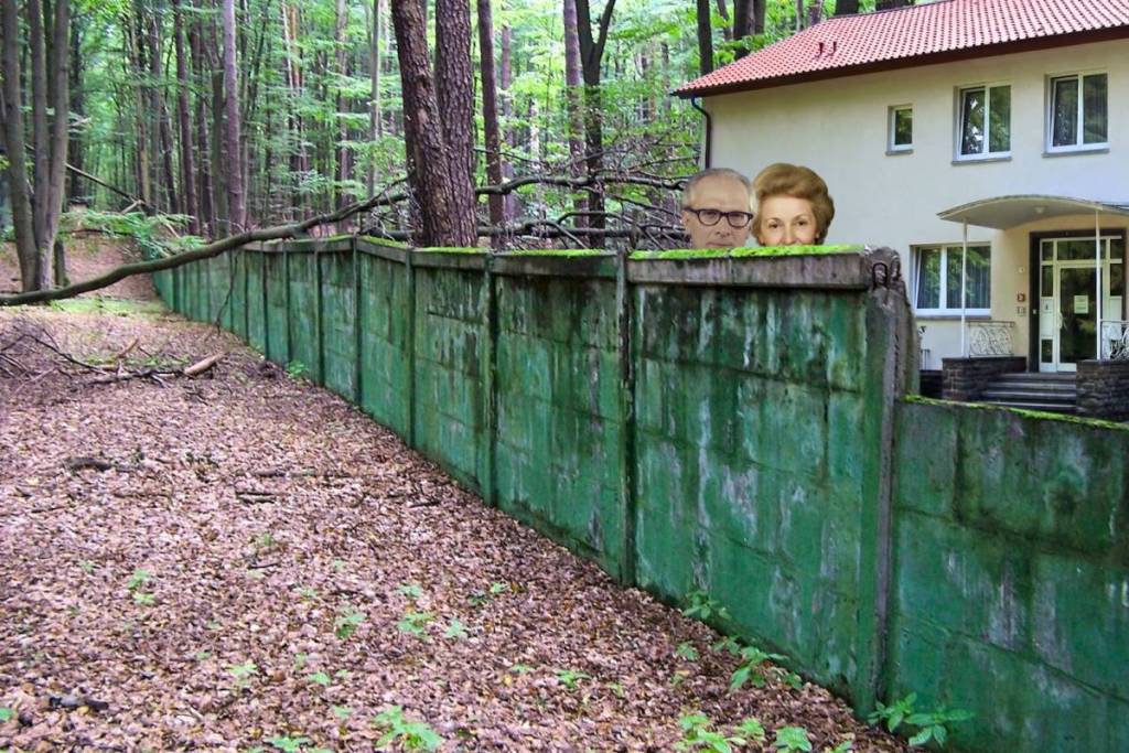 Un fotomontaggio che accompagna l’articolo: i volti dell’ex capo di Stato della DDR Erich Honecker e di sua moglie Margot si affacciano oltre il muro di cemento verde e ricoperto di muschio del Waldsiedlung; sullo sfondo a destra si vede la loro casa.