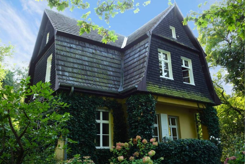 Une maison de campagne historique, entretenue avec amour, à la façade recouverte de lierre, nichée en pleine nature sur l’île de Valentinswerder.