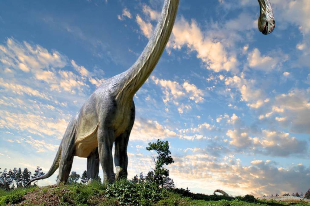 Riesige Brachiosaurus-Figur vor blauem Wolkenhimmel im Dinosauriermuseum Germendorf