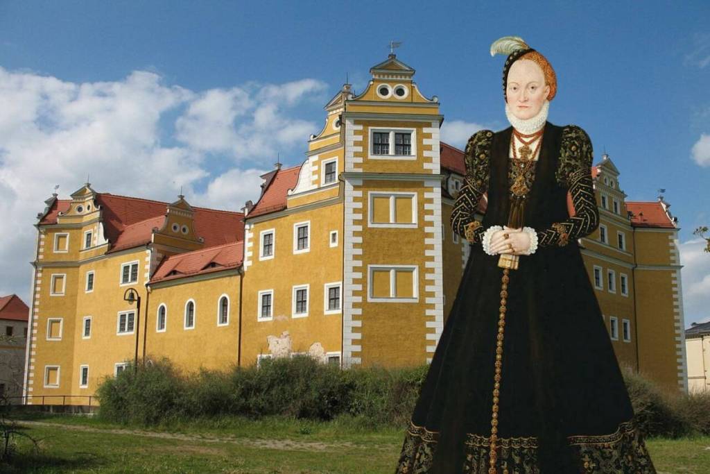 Raffigurazione storica della principessa elettrice Anna di Danimarca davanti all’imponente scenario del castello rinascimentale giallo di Annaburg, in Sassonia-Anhalt.