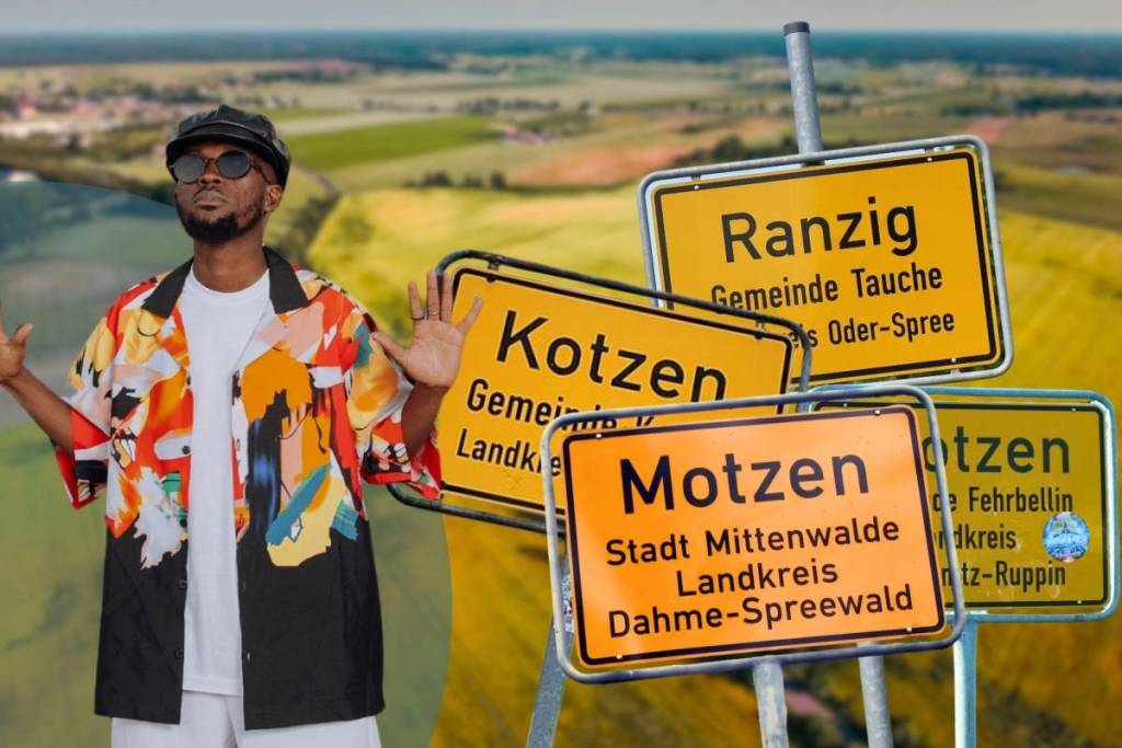 Un homme stylé, avec des lunettes de soleil et une chemise colorée, prend la pose avec humour à côté d’un collage représentant les curieux panneaux de localité brandebourgeois : Kotzen, Ranzig, Motzen et Protzen.