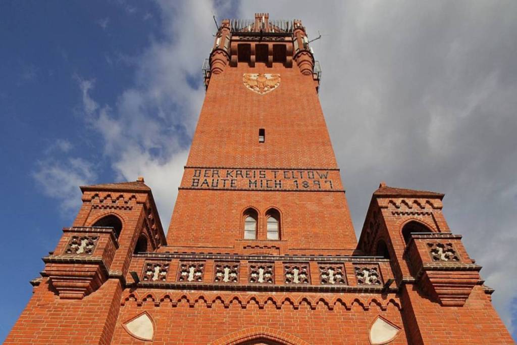 Primer plano de la fachada de ladrillo rojo de la histórica torre de Grunewald, con sus inscripciones, todo un símbolo de la ruta de senderismo por el Havelhöhenweg.
