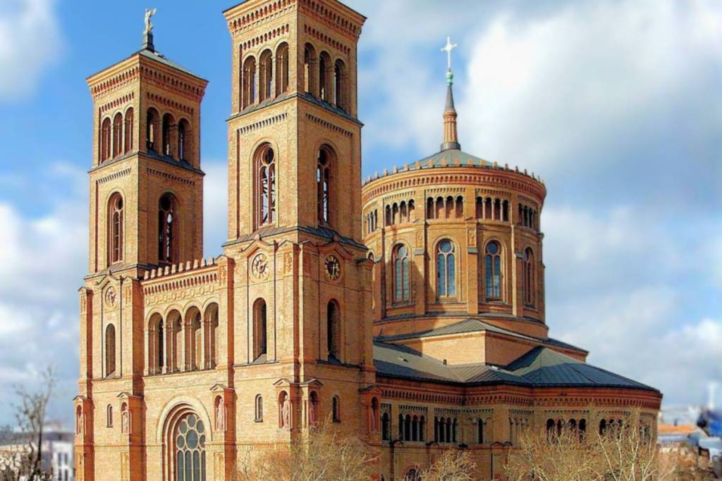 Vista esterna della storica chiesa di San Tommaso in Mariannenplatz a Berlino-Kreuzberg, con le sue imponenti torri gemelle e la grande cupola.