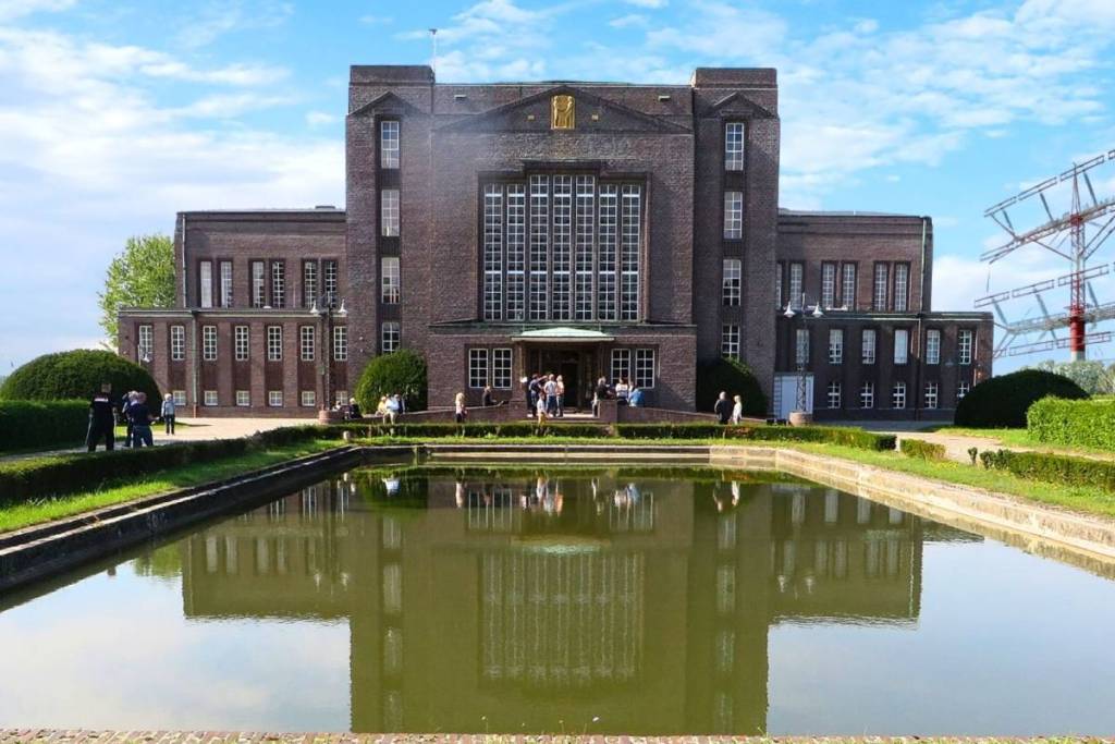 Het historische hoofdgebouw van het grote radiostation Nauen met zijn expressionistische bakstenen gevel van Hermann Muthesius, dat weerspiegeld wordt in het water.