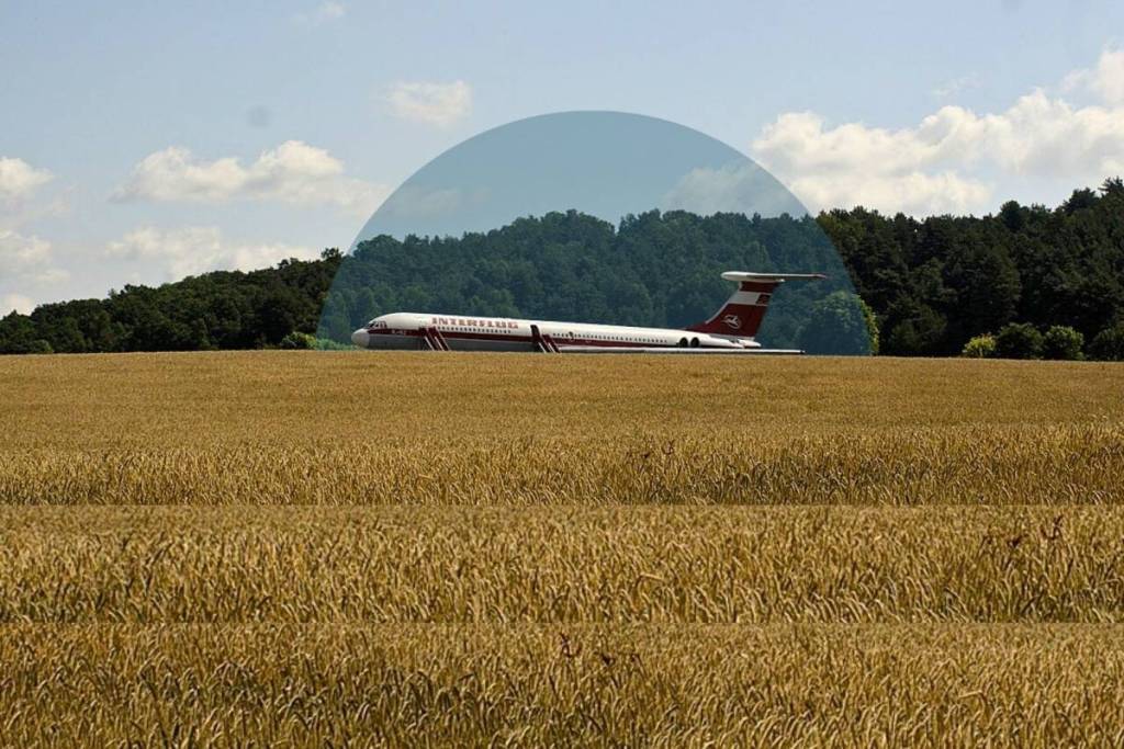 Seitenansicht der Interflug Iljuschin Il-62 'Lady Agnes' in den Feldern am Gollenberg bei Stölln, Brandenburg, mit dem Hügel im Hintergrund.