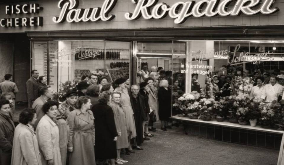 Die bekannteste Feinkost-Adresse in Berlin ist gleich doppelt zurück, zunächst mit Kochbuch, Produkten &amp; Pop-ups sowie 2028 mit neuem Stammhaus zum 100. Jubiläum