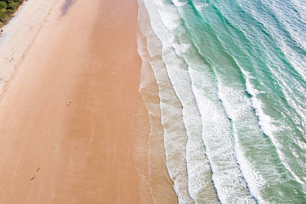 Aerial view of waves breaking on Tenby Beach, Wales, UK, one of many beaches near Birmingham