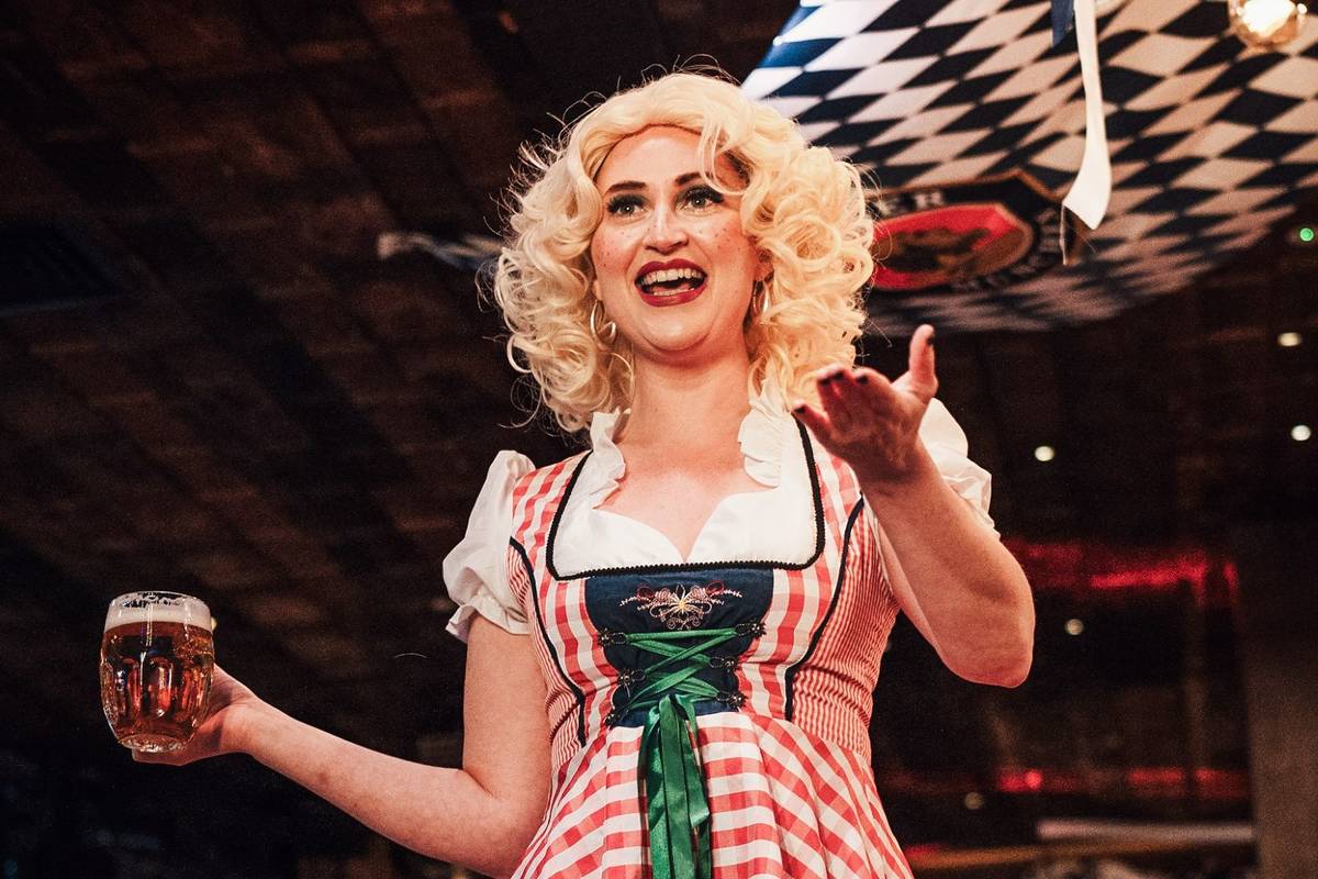 A woman in lederhosen carrying bier from Albert's Schloss at Oktoberfest