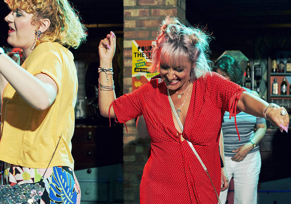 A woman in a read dress dancing