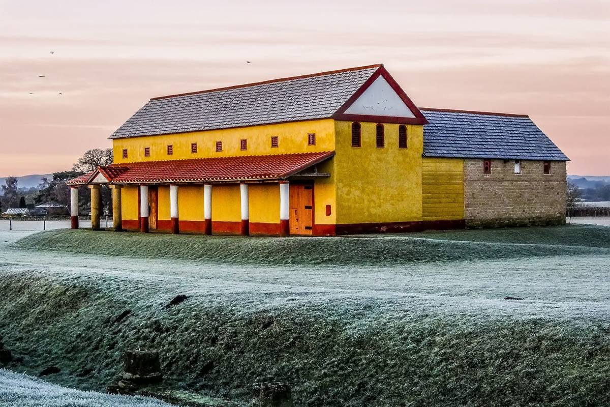 A view across the frost covered fields at Wroxeter, UK towards the reconstructed Roman town house just before sunrise