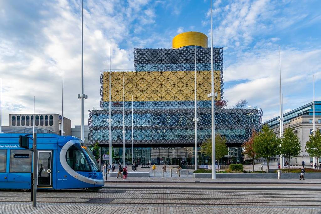 CENTENARY SQUARE, BIRMINGHAM, UK - OCTOBER 5, 2023. The postmodern exterior of The Library of Birmingham in Centenary Square with a West Midlands Tram providing local transport