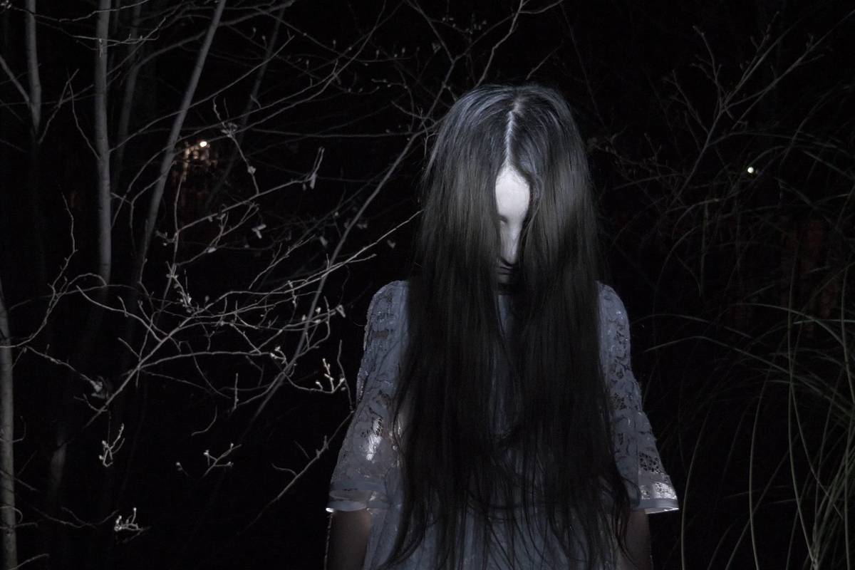 A creepy, ghostly girl in the woods, reminiscent of the Black-Eyed Child