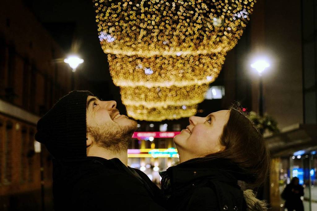 Two people looking up at a light installation