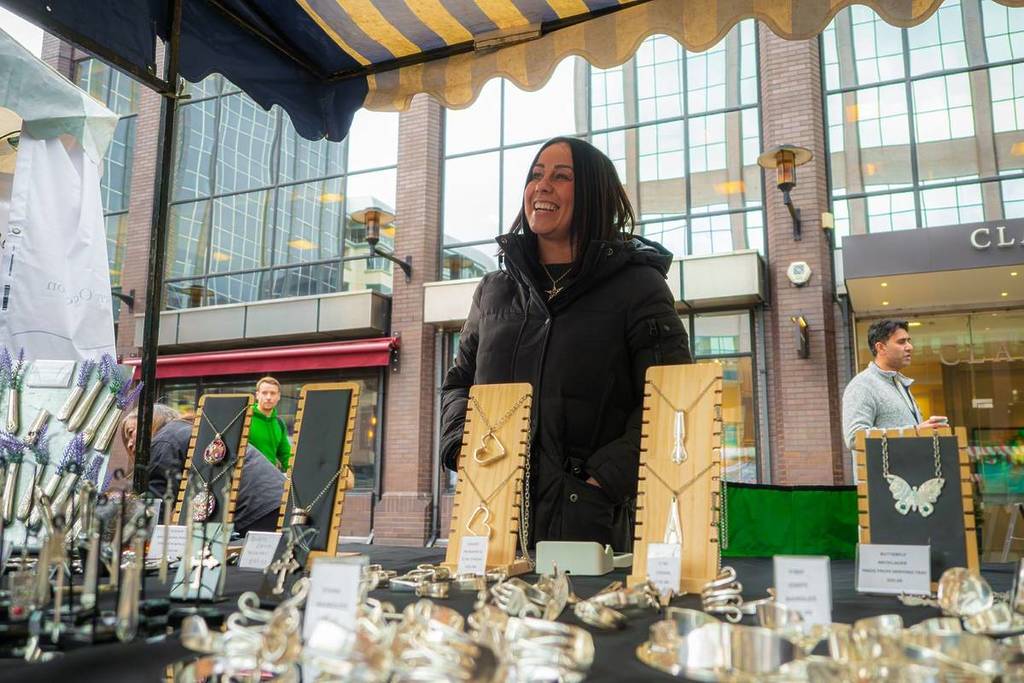 A woman selling necklaces at an artisan market