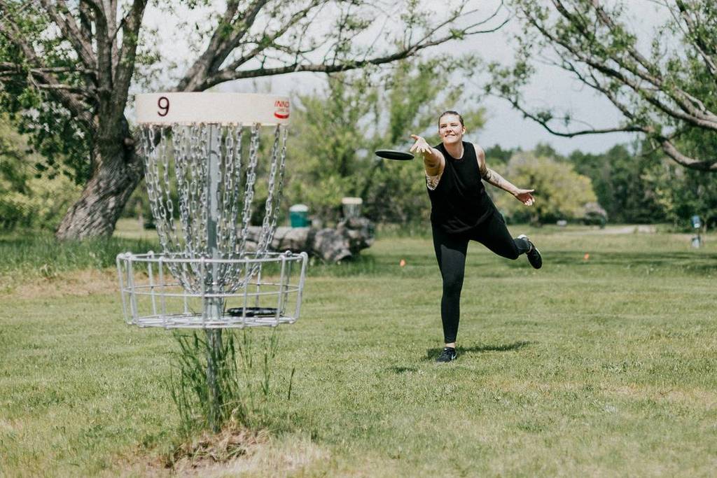 A woman playing disc golf