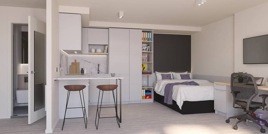 One of the studio rooms at Vita Student in central Birmingham, with a double bed and a kitchen with counter seating