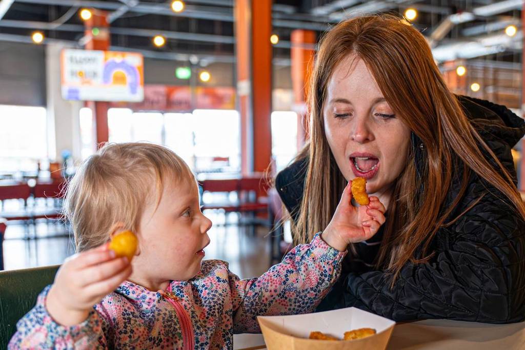 A child feeding a mother at Alfred Works
