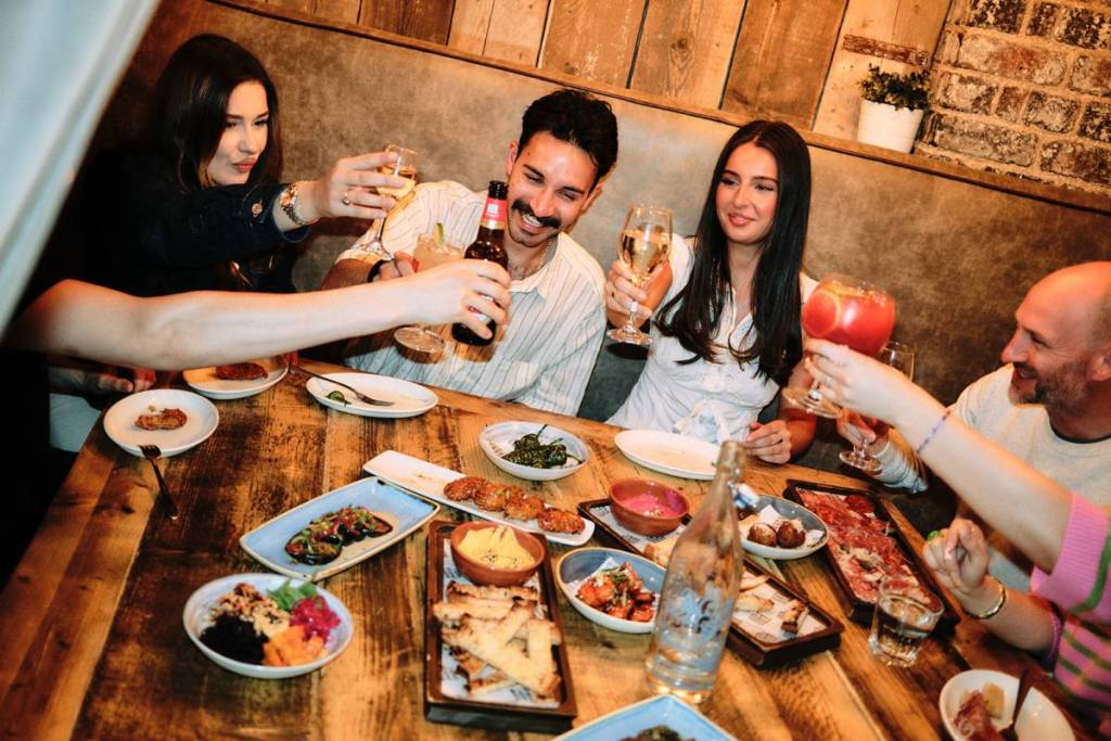 A group of people sat around enjoy tapas at Baresca Tapas