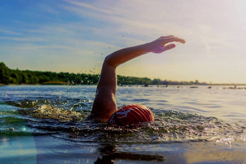 A person swimming at sunset