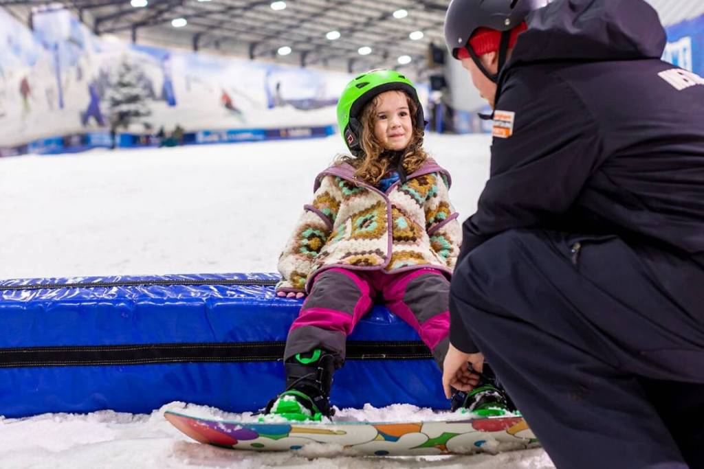 A child learning to snowboard